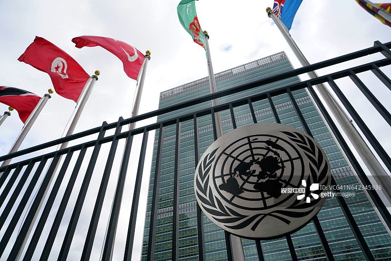 带有联合国成员国旗帜和秘书处大楼的联合国徽标图片素材