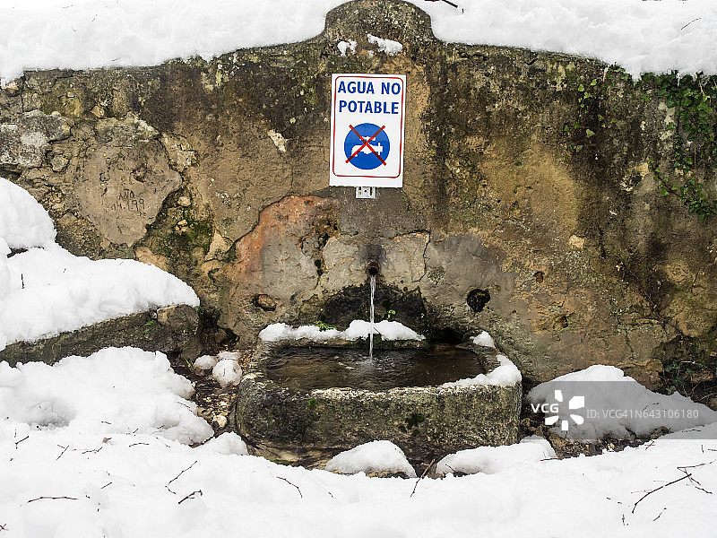 冬季覆盖着雪的田野里的水源（不可饮用的喷泉）图片素材
