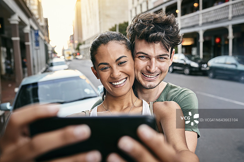 在城市里自拍的快乐年轻夫妇图片素材