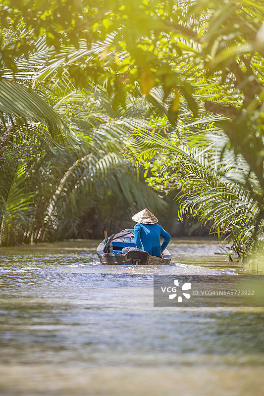 女人在湄公河三角洲驾驶船只图片素材