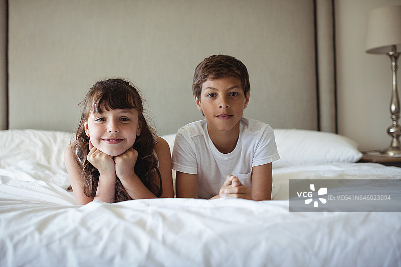 姐弟在床上微笑图片素材
