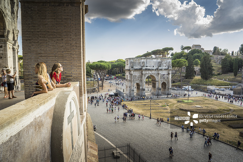 游客在罗马斗兽场欣赏风景，背景是君士坦丁凯旋门图片素材