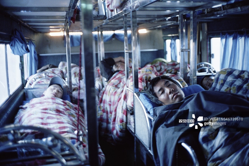 在公共汽车上睡觉的移民工人图片素材