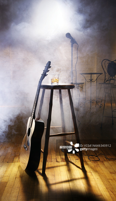 夜总会中倚靠在凳子上的原声吉他图片素材