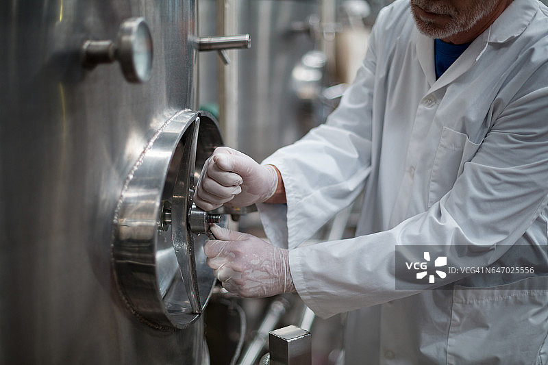 工厂工程师转动储罐的控制轮图片素材