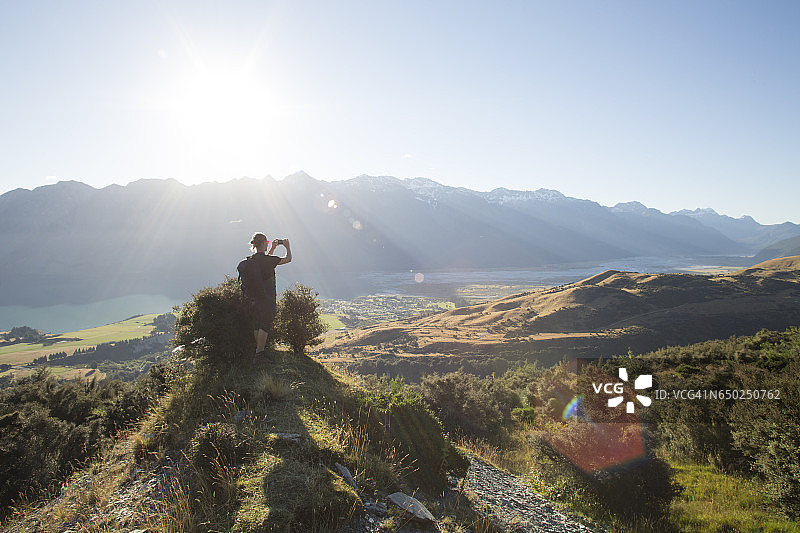 男人站在山脊上拍照图片素材