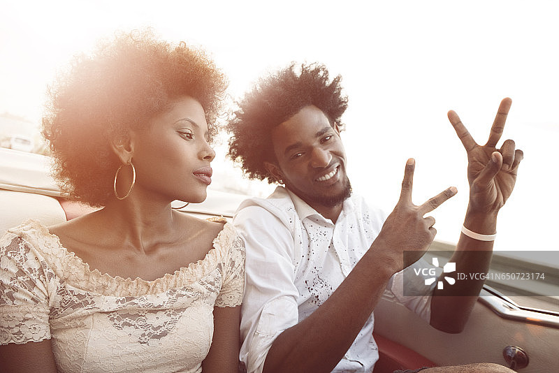在古巴哈瓦那，一对幸福的夫妇乘坐老式敞篷车兜风图片素材