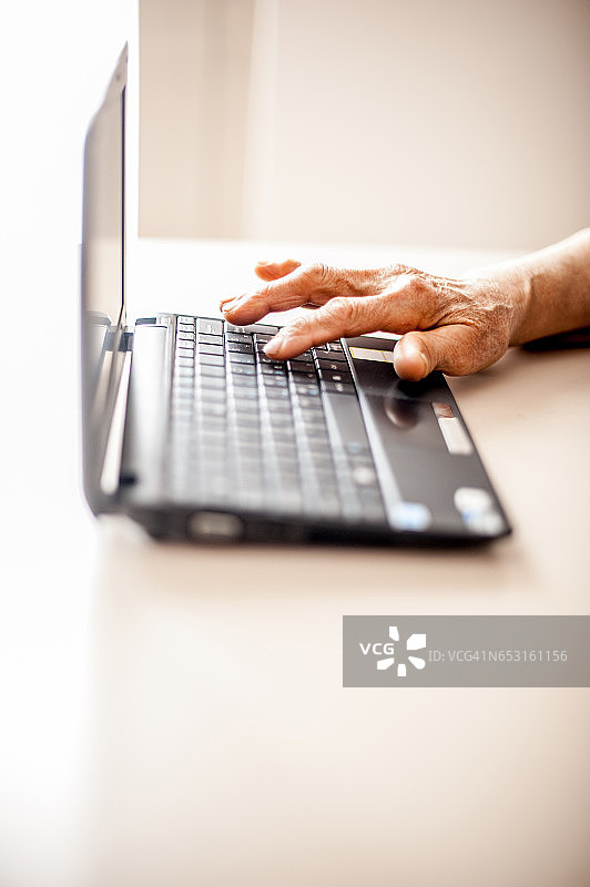 老年妇女使用笔记本电脑特写图片素材