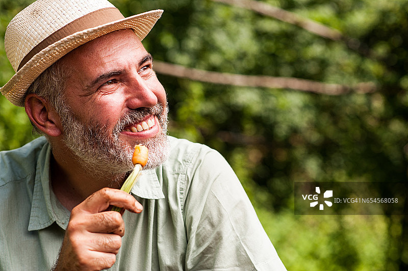 快乐的农民享受生吃胡萝卜图片素材