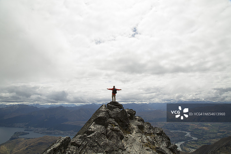 男人站在山顶伸开双臂图片素材