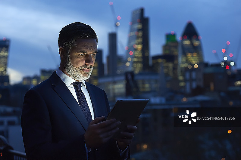 夜晚使用数位平板的商人图片素材