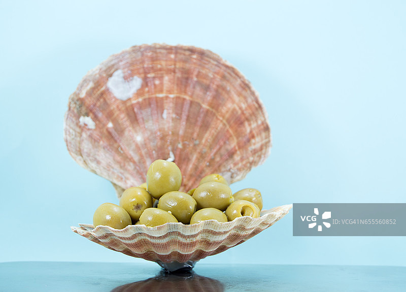 装满绿色橄榄的扇贝壳图片素材