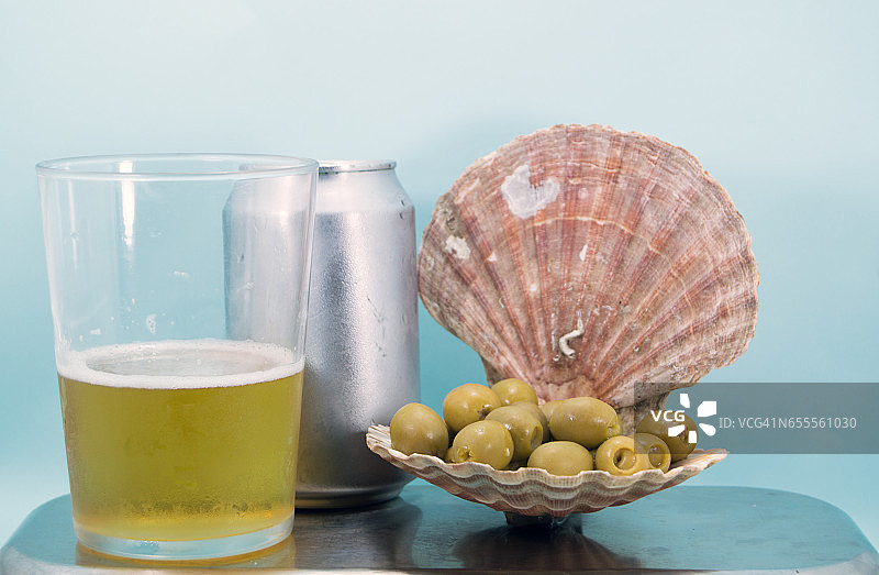 扇贝壳装满绿色橄榄和啤酒图片素材