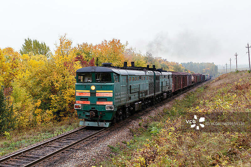 秋景中 мощ的柴油机车牵引重型货运列车图片素材