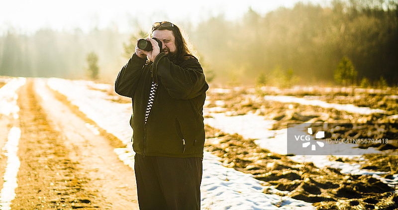 50岁的白人中年男人，留着胡须和长发，在白俄罗斯拍摄乡村风光图片素材