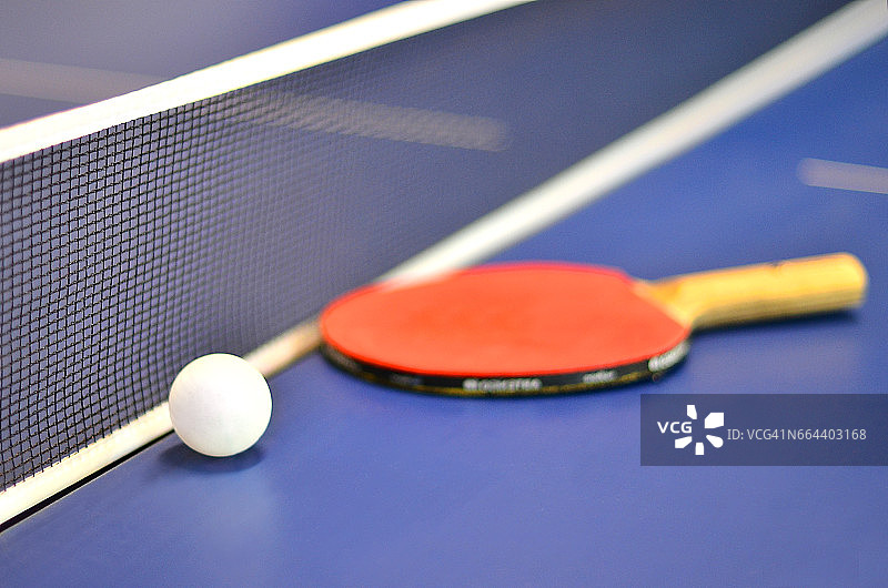 蓝色乒乓球桌上的乒乓球拍和球图片素材
