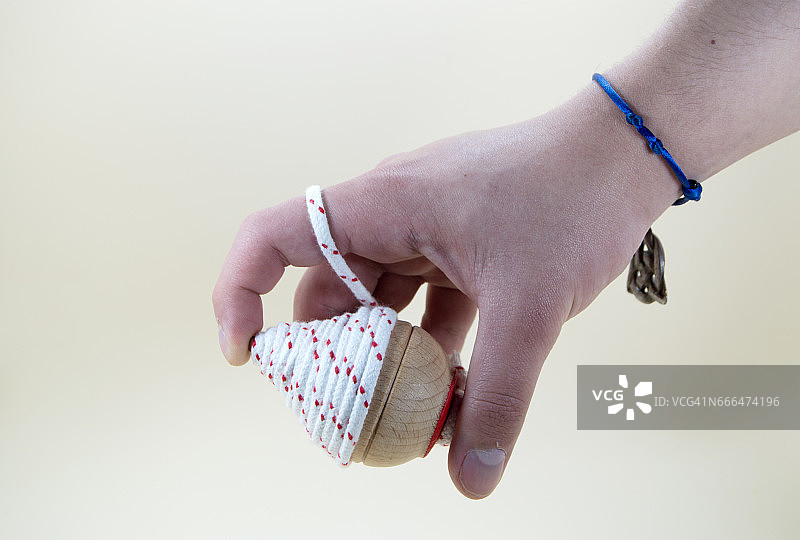 男孩的手缠绕着陀螺的绳子图片素材