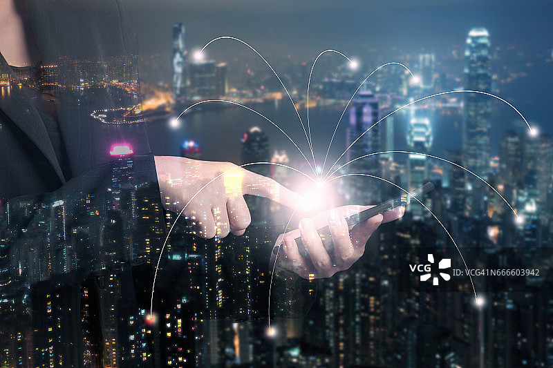 商务女士使用智能手机与模糊城市夜景及网络连接概念的双重曝光图片素材