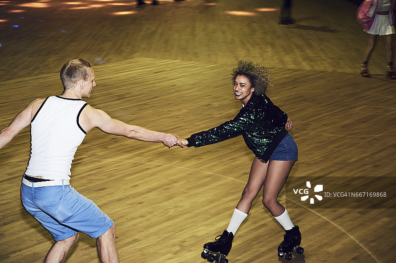 情侣在旱冰舞厅的欢乐时光图片素材