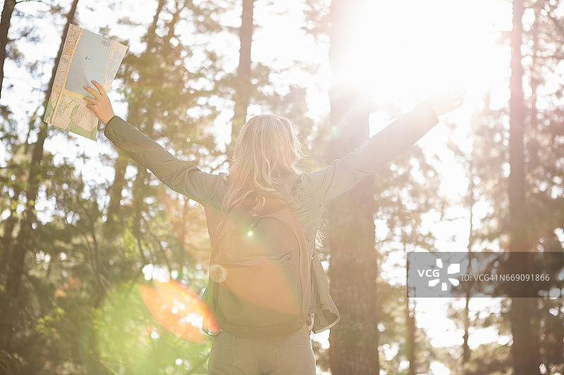 一位伸出双臂的快乐金发徒步旅行者图片素材