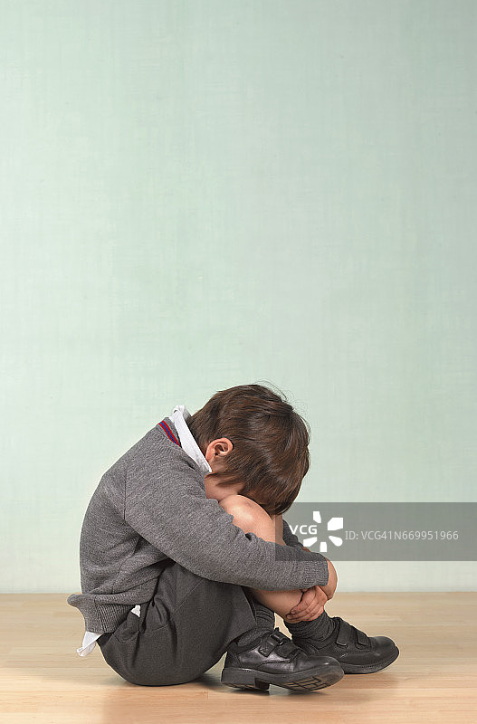 沮丧的男学生坐在地板上图片素材