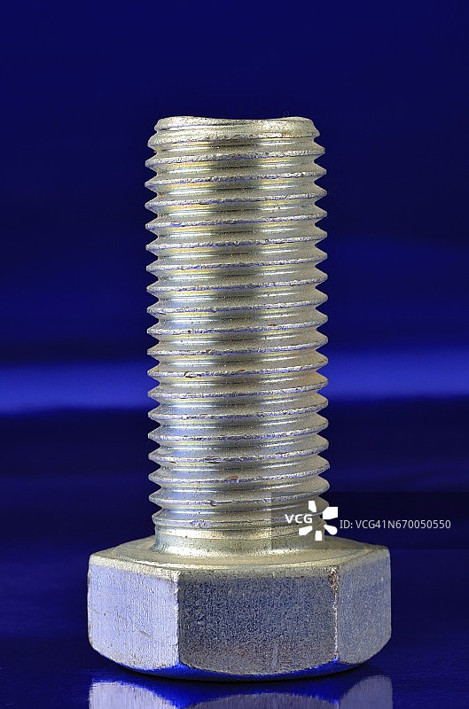 蓝色背景上的六角头紧固螺栓图片素材