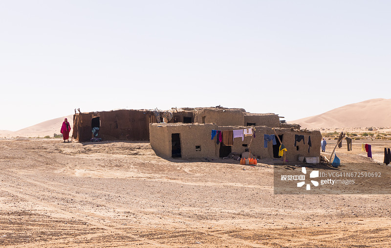 摩洛哥撒哈拉沙漠附近的摩洛哥柏柏尔房屋和柏柏尔妇女图片素材