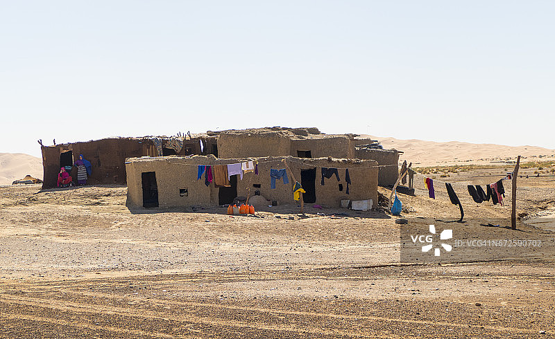 摩洛哥撒哈拉沙漠附近的摩洛哥柏柏尔房屋和柏柏尔妇女图片素材