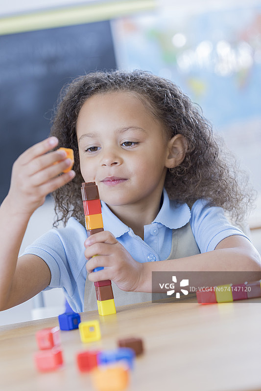 小女孩专心玩计数方块图片素材