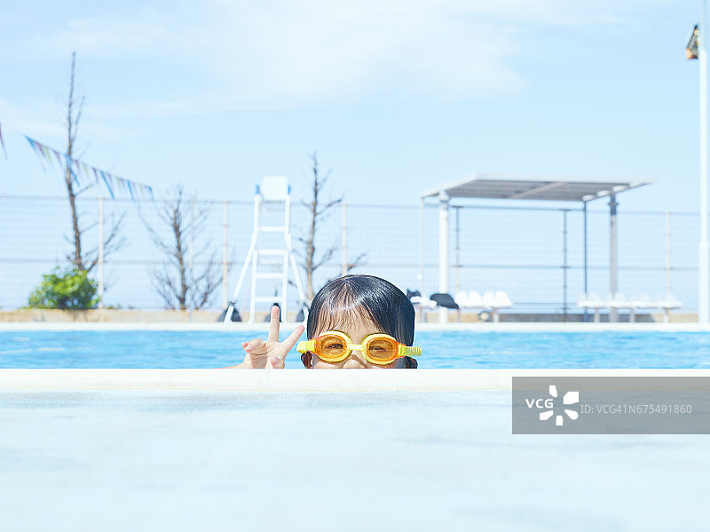 在游泳池里做和平手势的年轻女孩图片素材