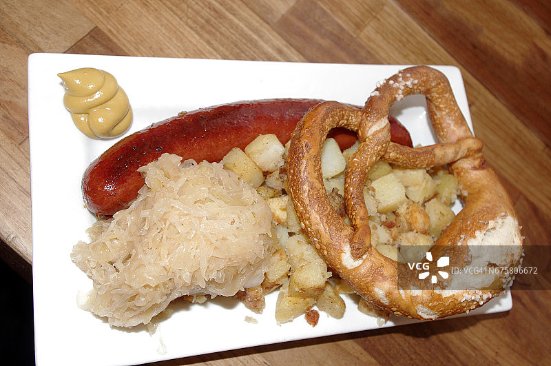 搭配炸土豆、酸菜、椒盐卷饼和芥末酱的德国香肠图片素材