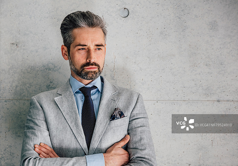 沉思的商人靠墙而立图片素材