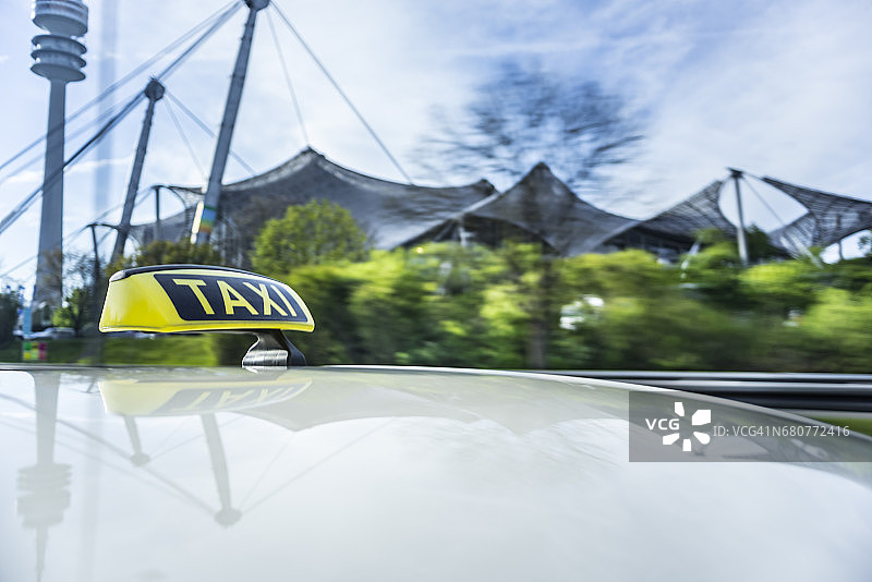 行驶中汽车长曝光拍摄，出租车车顶标志及电视塔背景虚化图片素材