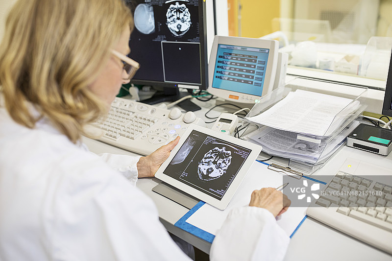 中年医生在平板电脑上查看X光片影像图片素材