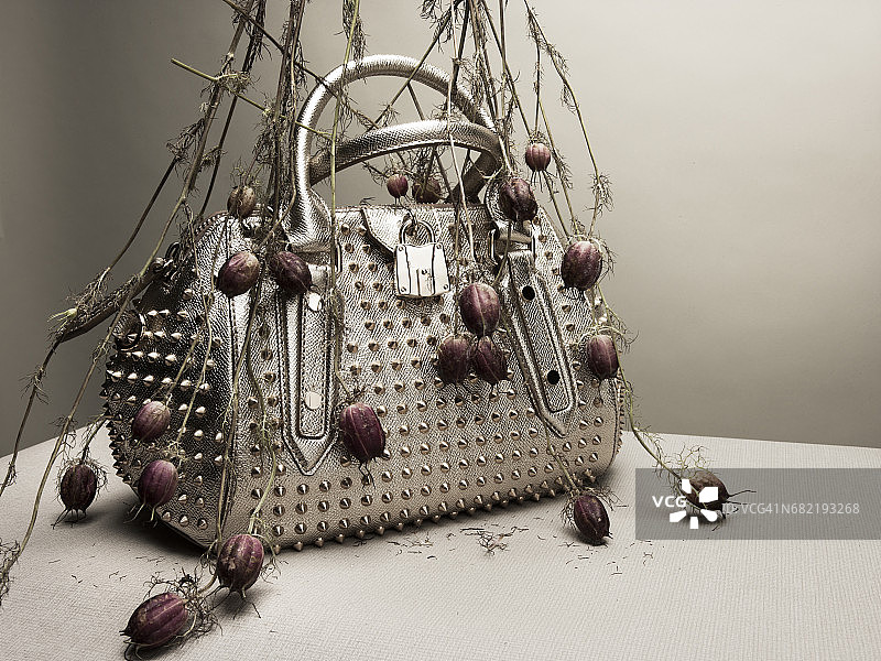 花朵之间的银色金属手提包图片素材