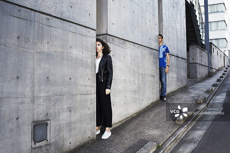 男孩和女孩从墙后露出半个身子图片素材