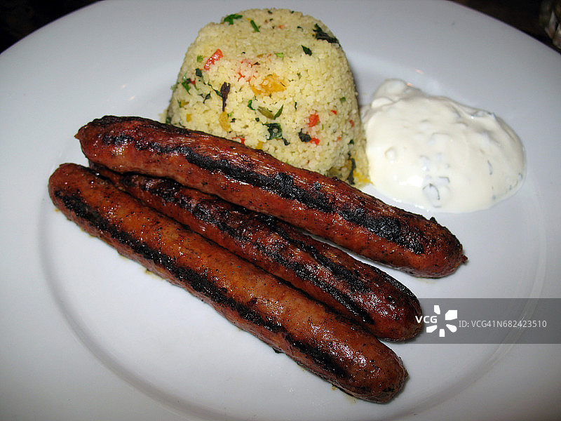 蔬菜古斯米饭佐薄荷酸奶蘸酱的香辣摩洛哥香肠图片素材