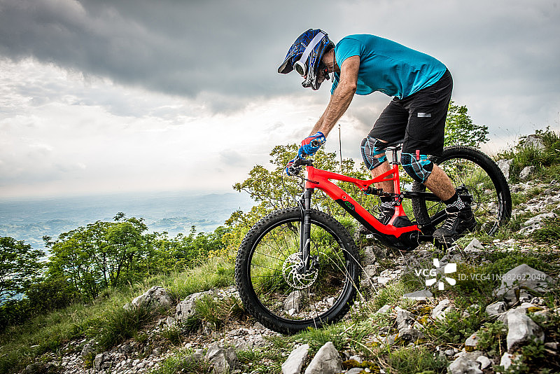 Enduro全山地电动自行车骑手 - 城市上方的肾上腺素MTB小径图片素材