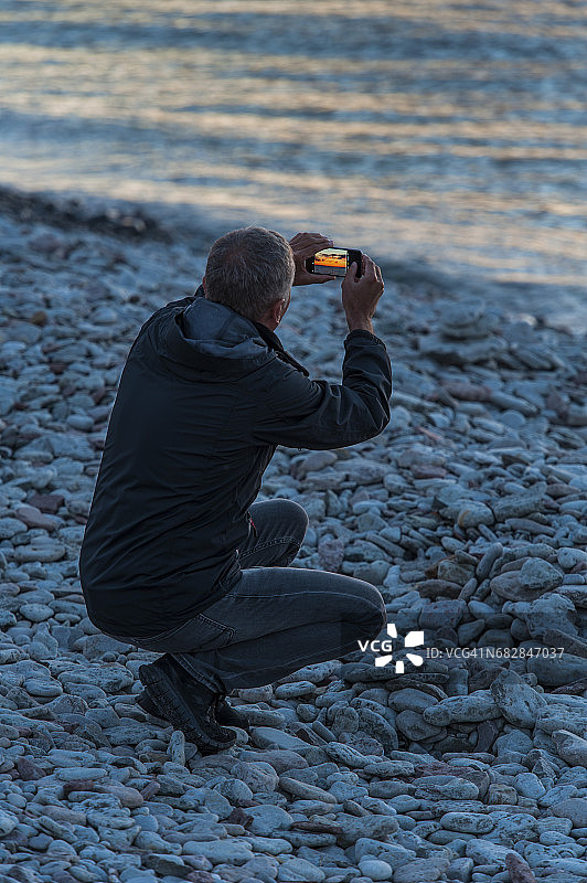 男人用手机拍摄日落图片素材
