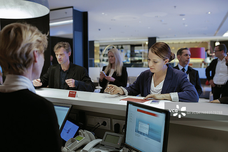 在酒店前台办理入住的女商人图片素材