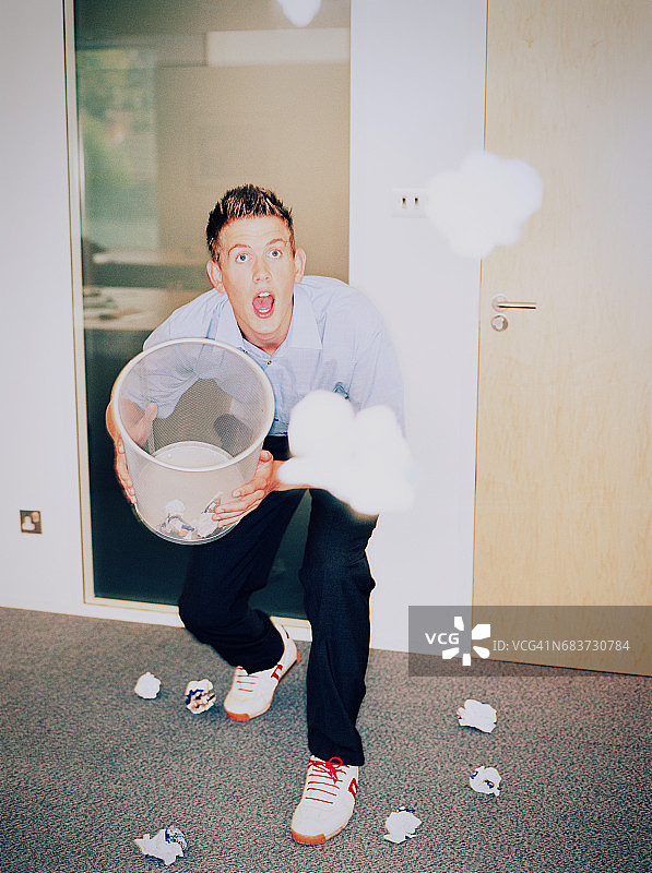 男人将纸球投入废纸篓图片素材