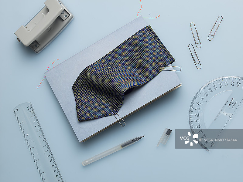 蓝色笔记本，附有蓝色男士领带和办公文具图片素材