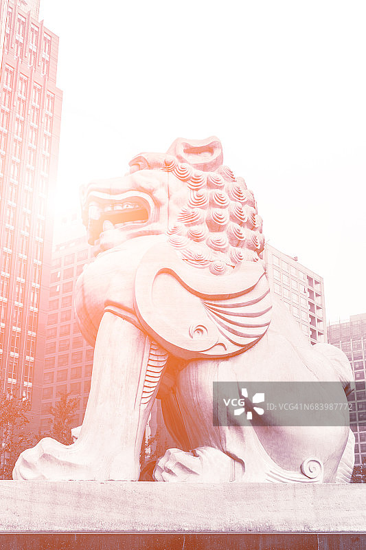 现代摩天大楼旁边的中国石狮雕像图片素材