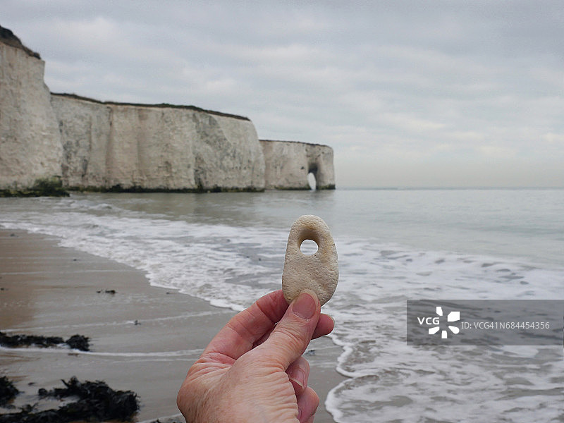 手持带孔的白垩石图片素材