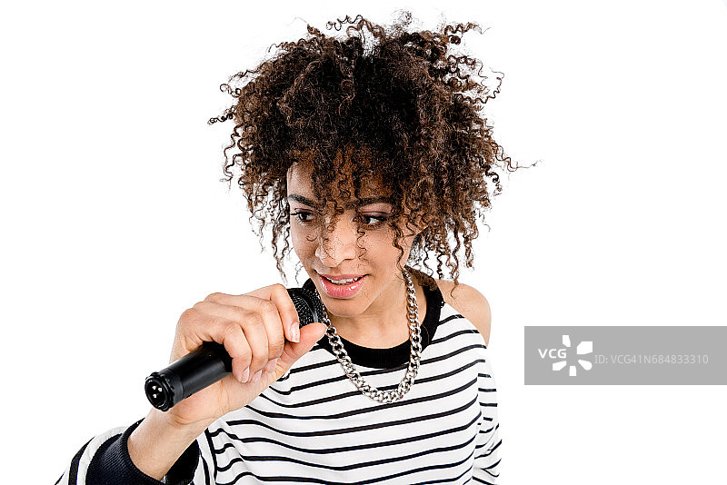 微笑的女人拿着麦克风在白色背景上唱歌，重金属歌手概念图片素材