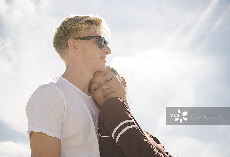 阳光下，女人和男友沐浴在蓝天中图片素材