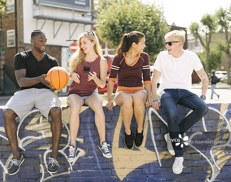 在城市滑板公园聊天的男女篮球爱好者图片素材