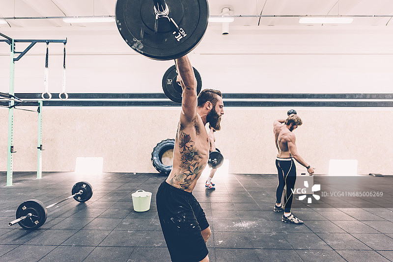 健身房里举杠铃的年轻男人图片素材