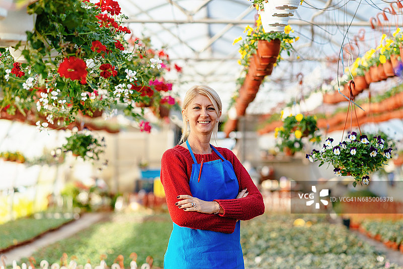 自豪的女企业家站在她的植物苗圃旁图片素材