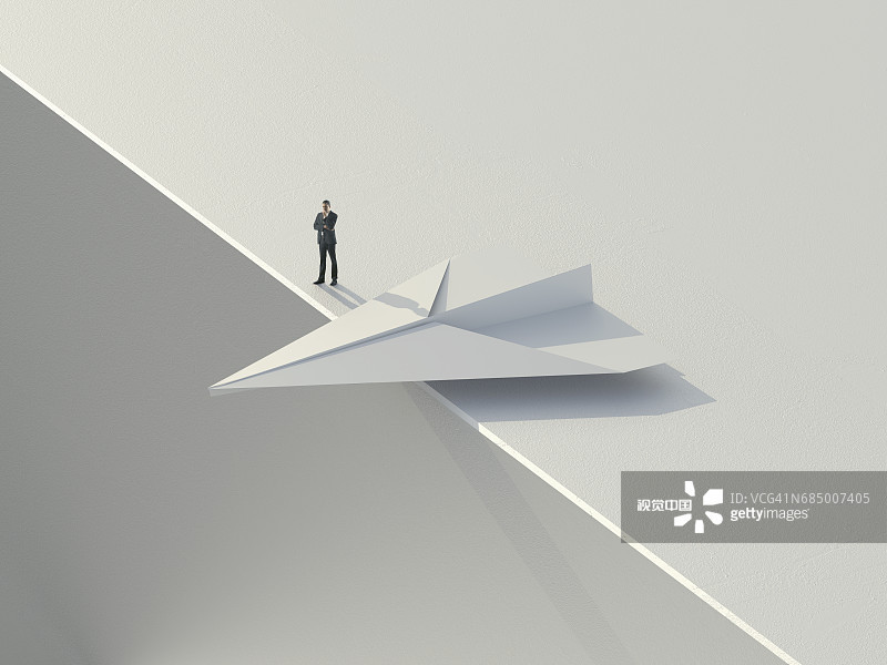 站在摇摇欲坠的纸飞机旁的白人商人图片素材